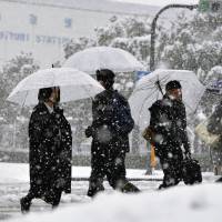 Heavy snowfall in front of Tottori Station on Friday. | KYODO