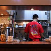 A little slice of the Philippines in Tokyo: A staff member of Ate in Nishi-Ogikubo prepares a dish. Exploring the evolution of Filipino cuisine in Japan