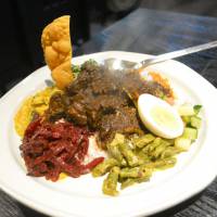To mix or to match?: The Newara plate can be tailored to a variety of tastes, but this one features pickled beets, roasted coconut, green beans, cucumbers and curried mutton. Mix it all together, or savor its many parts. | J.J. O’DONOGHUE