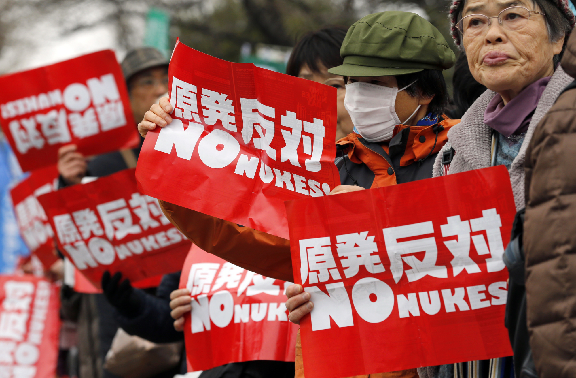 Anti-nuclear protesters hold placards in front of the Diet building in Tokyo last year. The majority of Japanese people remain opposed to restarting the nation's nuclear reactors in the wake of the Fukushima nuclear disaster. Only 5 percent of Japanese surveyed in a poll last year said they would like to see Japan become a nuclear weapons power. | AP