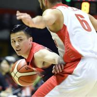 Japan\'s Yuki Togashi looks to pass the ball as Iran\'s Amirhossein Azari defends during the fourth quarter of Friday\'s exhibition game in Sapporo. Japan defeated Iran 85-74. | KYODO