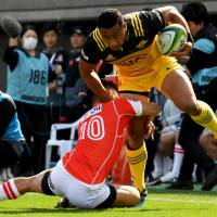 The Hurricanes\' Ngani Laumape attempts to get past the Sunwolves\' Hikaru Tamura on Saturday. | AFP-JIJI