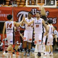 Osaka Evessa teammates Takuya Hashimoto (left), Xavier Gibson (center) and Josh Harrellson celebrate their 84-81 victory over the Kawasaki Brave Thunders on Saturday in Hiratsuka, Kanagawa Prefecture. Evessa rally past Brave Thunders in fourth quarter, snap four-game losing streak