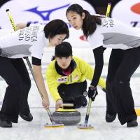 The Chubu Electric Power teams plays a shot at the national curling championships on Sunday. | KYODO