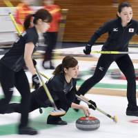 Japan\'s women\'s curling team launches a stone during its 7-5 defeat to South Korea at the Asian Winter Games in Sapporo on Monday. | KYODO