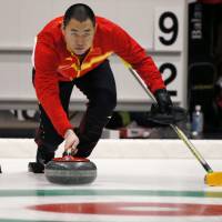 China\'s Liu Rui throws the stone against Japan in the men\'s curling final at the Asian Winter Games in Sapporo on Friday. | AP