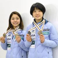 Ski jumpers Sara Takanashi (left) and Yuki Ito pose with their medals on Tuesday at Narita airport after returning from Lahti, Finland, where they competed in the Nordic Ski World Championships. | KYODO