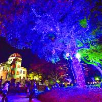 Trees near the Atomic Bomb Dome in Hiroshima are illuminated with LED lights on Dec. 7. The event, which ends Sunday, started in December to commemorate the 20th anniversary of the dome\'s addition to the UNESCO World Heritage List. Some have questioned whether it is appropriate to promote the event for tourism purposes. | KYODO