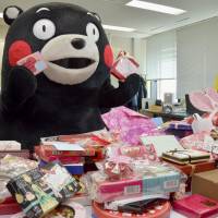 Kumamon, the popular mascot of Kumamoto Prefecture, holds Valentine\'s Day chocolates sent for him at the prefectural government office in Kumamoto on Wednesday. The prefecture said Kumamon products racked up record sales of &#165;128 billion in 2016, with the mascot employed to support reconstruction efforts following major earthquakes last April. | KYODO