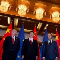 European Commission President Jean-Claude Juncker (left), Chinese President Xi Jinping and European Council President Donald Tusk pose before a meeting at the Diaoyutai State Guesthouse in Beijing in July. Trump's policies on trade, climate and the U.N. push China toward EU