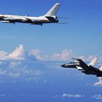 A Chinese People\'s Liberation Army Air Force Su-30 fighter (right) flies along with an H-6K bomber as they take part in a drill near the East China Sea last September. | AP