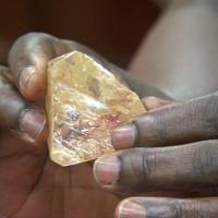 In this photo taken from video footage, Sierra Leone President Ernest Bai Koroma handles a diamond during a meeting with delegates of Kono district, where the gem was found, at the presidential office in Freetown Thursday. A pastor discovered the largest uncut diamond found in more than four decades in this West African country and turned it over to the government, saying he hopes it helps to boost recent development in his impoverished nation. | SLBC / VIA AP