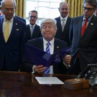 U.S. President Donald Trump, flanked by Commerce Secretary Wilbur Ross (left) and Energy Secretary Rick Perry, announces the approval of a permit to build the Keystone XL pipeline from the White House Oval Office on Friday. Keystone approval spells headache for Canada's Trudeau