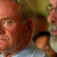 Martin McGuinness (left), Northern Ireland\'s deputy first minister at the time, watches as Sinn Fein leader Gerry Adams addresses the media at Stormont in Belfast, Northern Ireland, in September 2015. | REUTERS