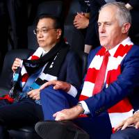 Australian Prime Minister Malcolm Turnbull sits with Chinese Premier Li Keqiang as they watch an Australian Football League game at the Sydney Cricket Ground in the Australian capital on Saturday. Australia cancels vote to ratify contentious extradition treaty with China