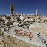 Graffiti sprayed by Islamic State militants reads, \"We remain\" on a stone at the Temple of Bel in the historic Syrian city of Palmyra on April 1, 2016. | REUTERS
