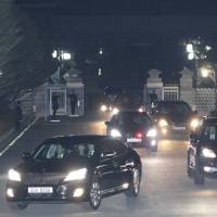 A vehicle (front left) carrying disgraced South Korean President Park Geun-hye (center, inside car)  leaves the presidential Blue House en route to her private home in Seoul on Sunday evening. | AP