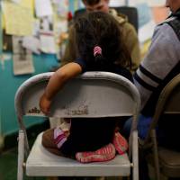 An undocumented immigrant family from Guatemala talks to a volunteer in January after arriving at Annunciation House, an organization that provides shelter to immigrants and refugees, in El Paso, Texas. | REUTERS