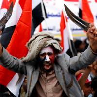 A man waves traditional daggers, or jambiyas, during a mass rally by supporters of the Houthi movement and former Yemeni President Ali Abdullah Saleh in Sanaa on Sunday. | REUTERS