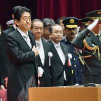 Prime Minister Shinzo Abe attends the graduation ceremony at the National Defense Academy in Yokosuka, Kanagawa Prefecture, on Sunday. | KYODO