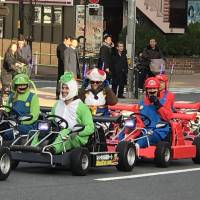 Tourists ride rented MariCar go-karts in Minato Ward, Tokyo, on Feb. 24. | MAGDALENA OSUMI