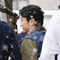 Rape suspect and former NHK reporter Yasutaka Tsurumoto is seen leaving a police station in Yamagata Prefecture Wednesday as he is being transferred to the Yamanashi Prefectural Police Department. | KYODO
