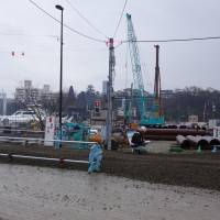 Construction continues in the fishing port of Kesennuma, Miyagi Prefecture, late last month. Six years after the 2011 quake-tsunami disaster, a planned full-fledged redevelopment project has yet to begin. | REIJI YOSHIDA