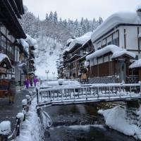 Snow-covered ryokan (traditional inns) stand in the Ginzan Onsen hot spring resort in Yamagata Prefecture. The estimated number of hotel stays by visitors to Japan hit a record 70.88 million in 2016, according to the Japan Tourism Agency. | ISTOCK
