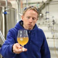 Chris Hainge, Kyoto Brewing co-founder and head brewer, shows off a sample early in the brewing process. | SATOKO KAWASAKI