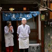 The owners of Tempura Tenshige in Kinshicho, Tokyo, stand in front of their shop. | KIT NAGAMURA