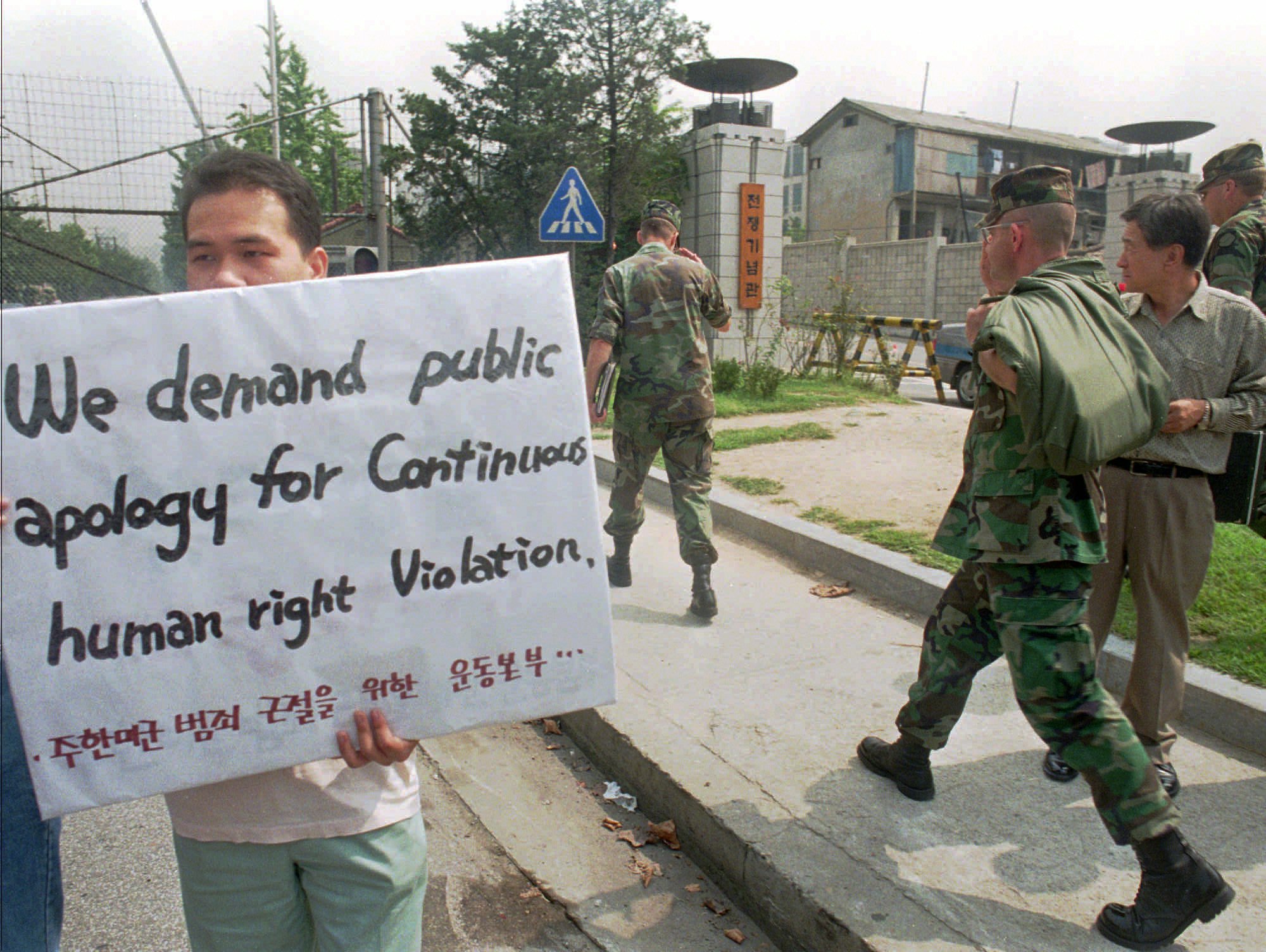 Outside the Yongsan U.S. Base in Seoul in 1996, U.S. soldiers pass by a student demanding the withdrawal of the U.S. military from South Korea. The protest was a response to the murder by a U.S. soldier of a prostitute in Tongduchon, 50 km north of Seoul. | AP