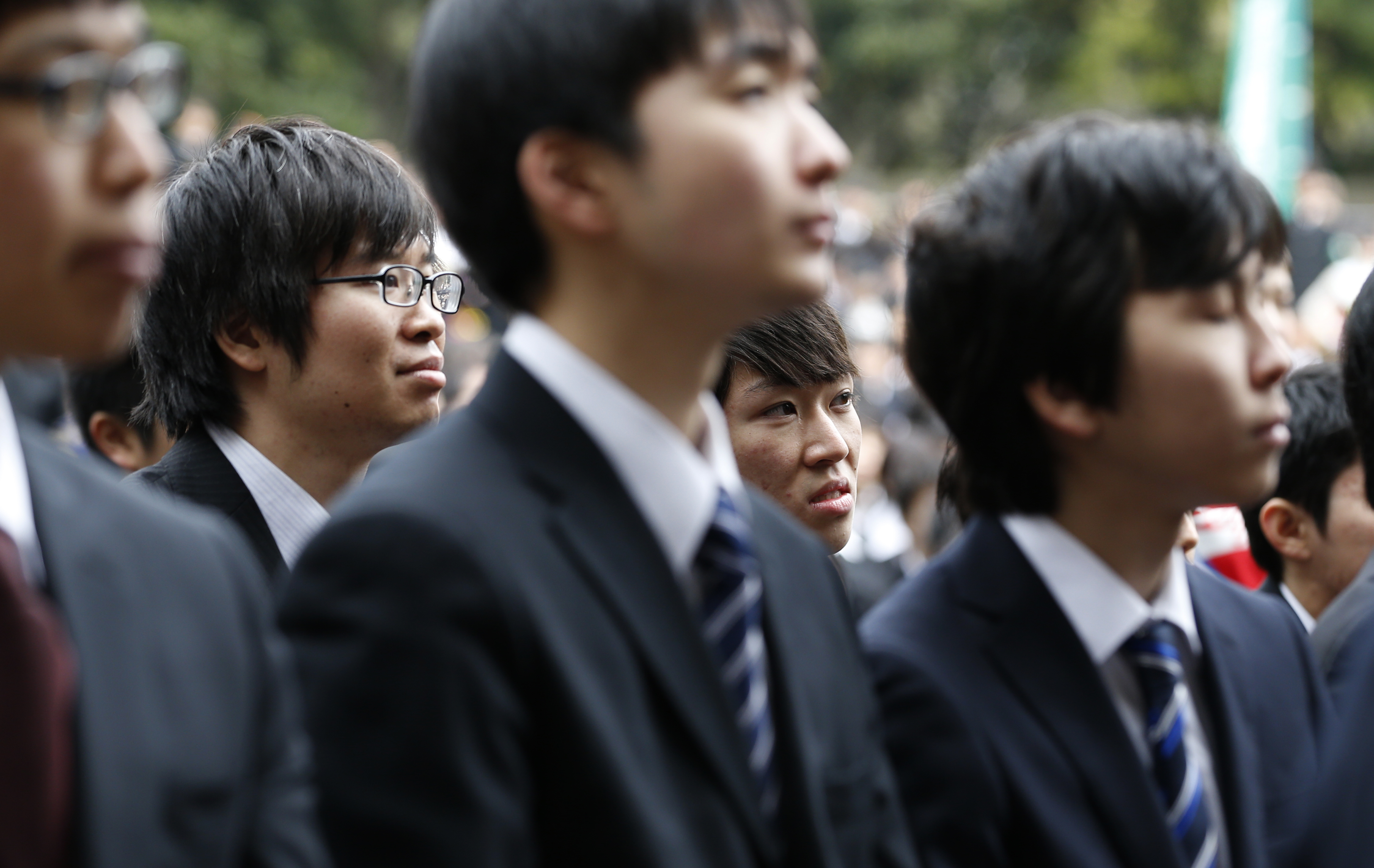 College students listen to a guest speaker during a ceremony to launch their job search at Tokyo's Hibiya Park on Wednesday. | AP