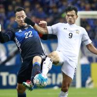 Japan\'s Maya Yoshida (left) and Thailand\'s Adisak Kraisorn vie for the ball during Tuesday\'s match. | AP