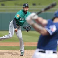 Seattle Mariners hurler Hisashi Iwakuma delivers a pitch in a spring training game against the Texas Rangers in Surprise, Arizona, on Friday. Iwakuma allowed one run and three hits in two innings of work in his first outing of the spring. | KYODO