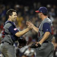 Buster Posey (left) and Luke Gregerson on the United States celebrate after beating Japan on Tuesday. | AP