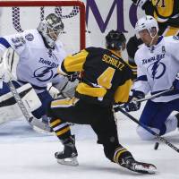 Pittsburgh’s Justin Schultz prepares to put a rebound past Tampa Bay goalie Peter Budaj and teammate Anton Stralman for a goal in the third period on Friday night. Streit scores in Pens debut