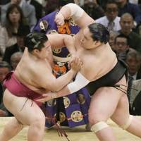 Endo (left) graples with Terunofuji on Thursday at the Spring Grand Sumo Tournament in Osaka. | KYODO