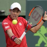 Kei Nishikori plays a shot from Kevin Anderson in their second-round match at the Miami Open on Friday. Nishikori won 6-4, 6-3. | AP
