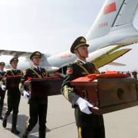 A Chinese honor guard carries caskets containing the remains of soldiers during a ceremony at Incheon International Airport in Incheon, South Korea, on Wednesday. The remains of 28 Chinese soldiers killed during the 1950-53 Korean War were transferred from the temporary columbarium in South Korea to the airport to return home for permanent burial. | POOL / VIA REUTERS
