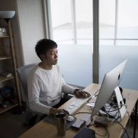 Kazz Watabe moved to the city of Fukuoka from Tokyo in late 2013 to develop smartphone apps and software. He can now see sea bass jump as he works on his website from his beachfront office. | BLOOMBERG
