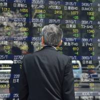 A man looks at a stock market board in Tokyo recently. | AFP-JIJI