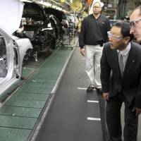 Production team member Steve Turley (right) and Toyota President Akio Toyoda look into a Camry on the assembly line at the Toyota Motor Manufacturing plant in Georgetown, Kentucky, in 2010. Toyota said Monday it is investing $1.3 billion to retool its sprawling Georgetown factory, where the company’s flagship Camry sedans are built. No new factory jobs are being added, but Toyota says the upgrades amount to the biggest single investment ever at one of its existing plants in the United States. Toyota announces $1.33 billion investment in Kentucky plant, adds plug at Trump's request