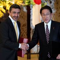 Abdullah bin Zayed Al Nahyan, foreign minister of the United Arab Emirates, and Foreign Minister Fumio Kishida shake hands after exchanging memorandums in the Iikura Guesthouse in Tokyo on Monday. | AFP-JIJI