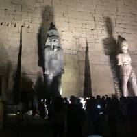 Tourists and Egyptians look at a huge granite statue of King Ramses II (center) following the completion of the restoration work, hours after the Egyptian Ministry of Antiquities revealed the contents of a pharaonic cemetery on the western bank of the Nile in Luxor, south of Cairo, on Tuesday. | REUTERS