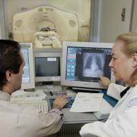 Dr. Claudia Henschke, chief of the Division of Chest Imaging, and CT supervisor Gus Daphnis watch the lung scan of a patient at New York Hospital-Cornell Medical Center in New York in 2005. The test, called a spiral or helical CT scan, detects lung abnormalities as small as 5 mm, less than a fifth of an inch. Blood tests seen tracking lung cancer gene changes, offering treatment hope