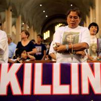 A woman prays for a loved one who she says was killed due to alleged involvement in illegal drugs during a Mass against extrajudicial killings at a Catholic church in the metropolitan Manila city of Paranaque on March 2. | REUTERS