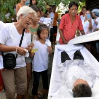 The grandmother of 5-year-old Francisco Manosca, son of Domingo Manosca, who according to relatives was a drug user, mourns during his funeral in the metropolitan Manila city of Pasay on Dec. 21. According to relatives and neighbors, unidentified gunmen killed both the father and child at their home. | REUTERS