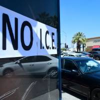 Motorists pass a \"No I.C.E\" protest statement posted on bus stop exterior in Bell Gardens, California, on Tuesday. Southern California\'s heavily Latino immigrant communities have been gripped by fear of U.S. Immigration and Customs Enforcement raids and deportations as Democrats push for a ban on ICE from courthouses. | AFP-JIJI