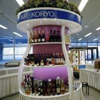 A vendor adjusts drinks at an Air Koryo bar at Pyongyang airport on April 11. | REUTERS