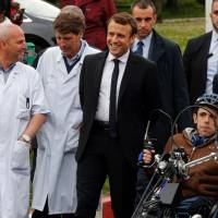 French presidential election candidate for the En Marche ! movement Emmanuel Macron (center) talks with doctors during his visit at the Raymond Poincare hospital in Garches outside Paris Tuesday. | PHILIPPE WOJAZER / POOL / VIA AFP-JIJI